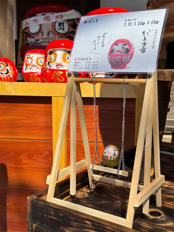 深大寺のだるま市境内のブランコに乗っただるま